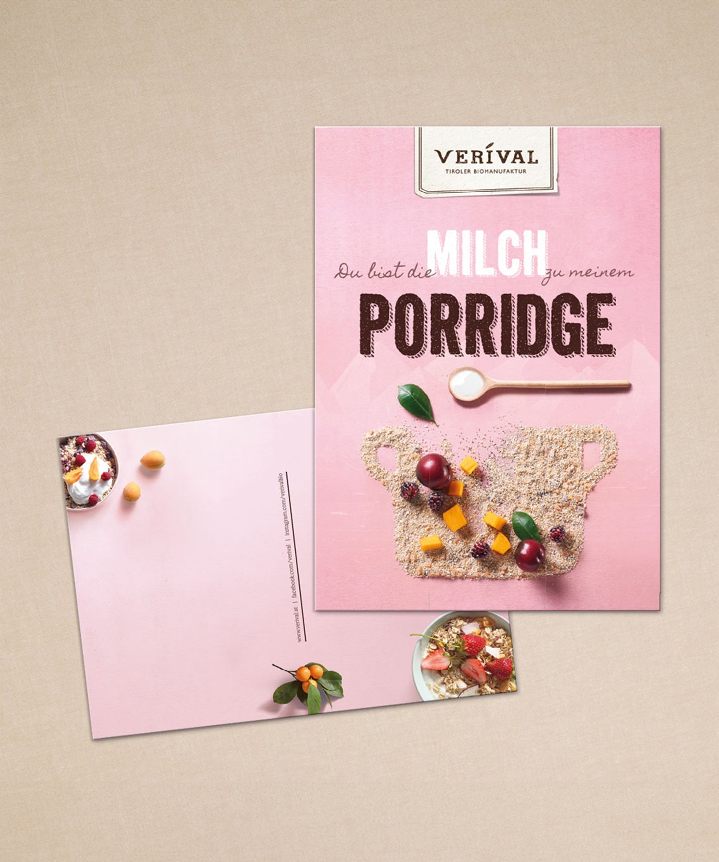 Die rosa Postkarte der Verival Bio GmbH zeigt eine Porridge-Schale mit Körnern, Obst und einem Löffel sowie eine Frühstücksschale mit Körnern und Obst. Sie eignet sich perfekt, um Geschenksets eine persönliche Note zu verleihen.