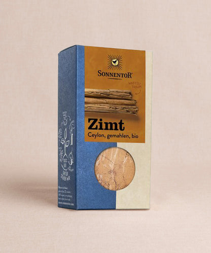 Erleben Sie die Bio-Authentizität von Sonnentors Ceylon Zimt gemahlen, ideal für Ihren morgendlichen Porridge. Die blau-beige Verpackung präsentiert Zimtstangen und ein transparentes Sichtfeld, welche einen Blick auf das Gewürz im Inneren der Packung erlaubt. 